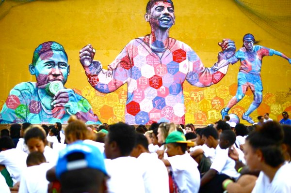The players gather on the pitch in front of the completed mural. Photo provided by Street Child World Cup.