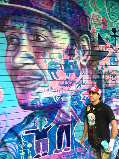 Said posing in front of his portrait